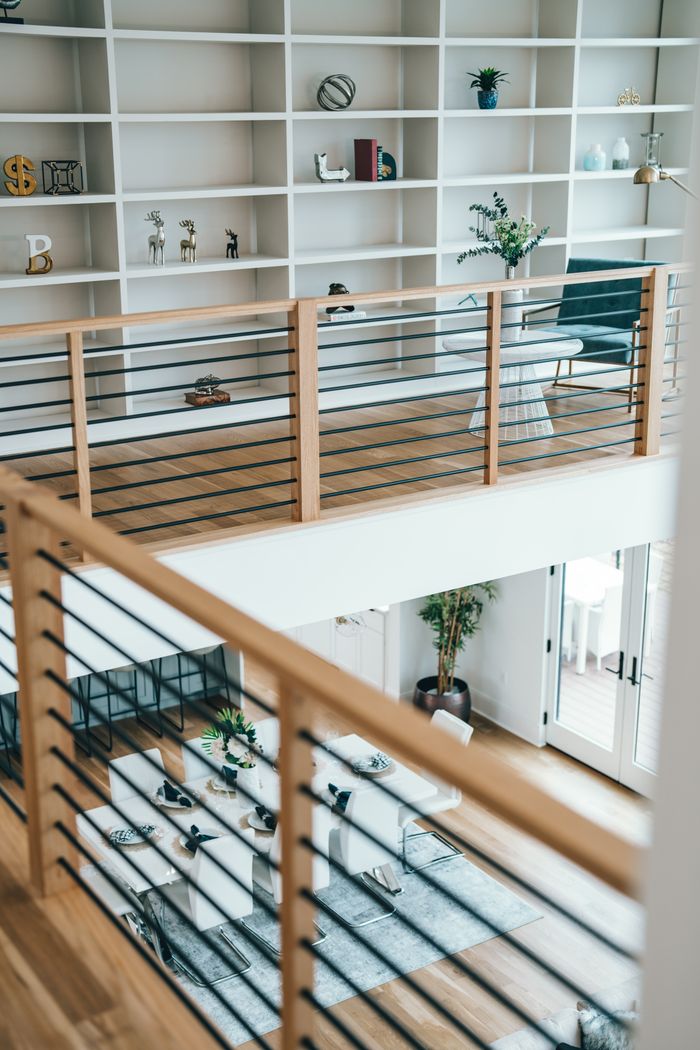 Bright and spacious home interior featuring a modern mezzanine with wooden railing and stylish decor.