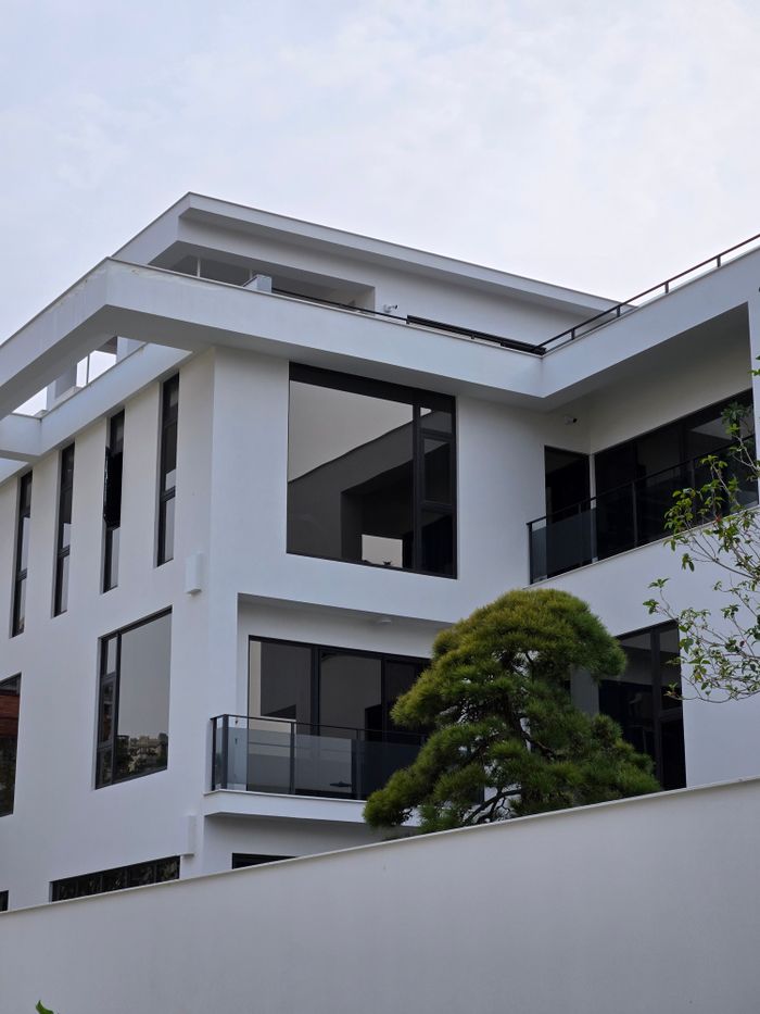 Services A sleek modern white building with large glass windows and minimalistic design.